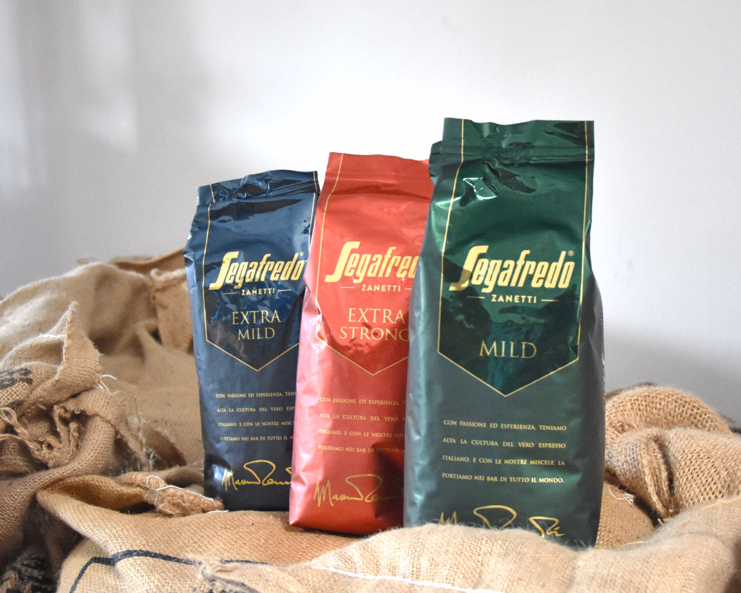 Drei Packungen Segafredo Kaffee für HoReCa stehen auf einigen Kaffeesäcken